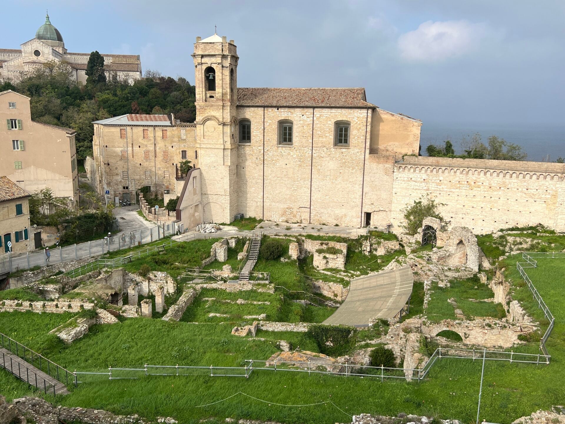 Historic ruins and church in a European cityscape.