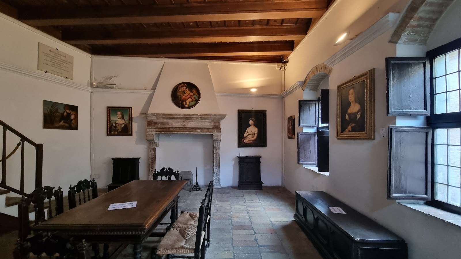 Historic room with paintings and wooden ceiling.