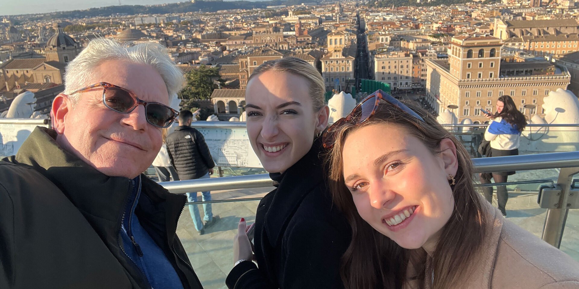 Group selfie overlooking cityscape.