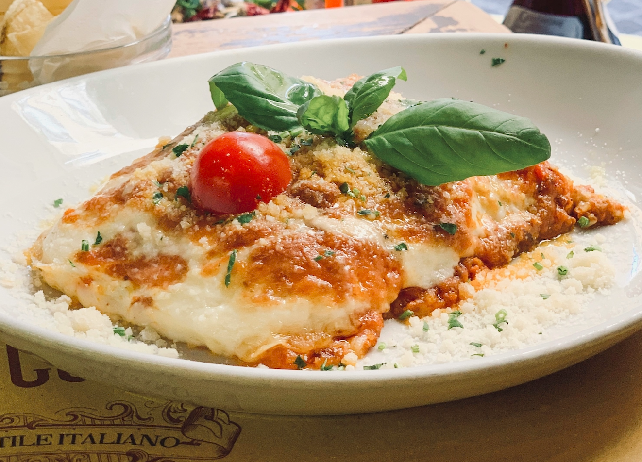 Cheesy lasagna with basil and cherry tomato garnish